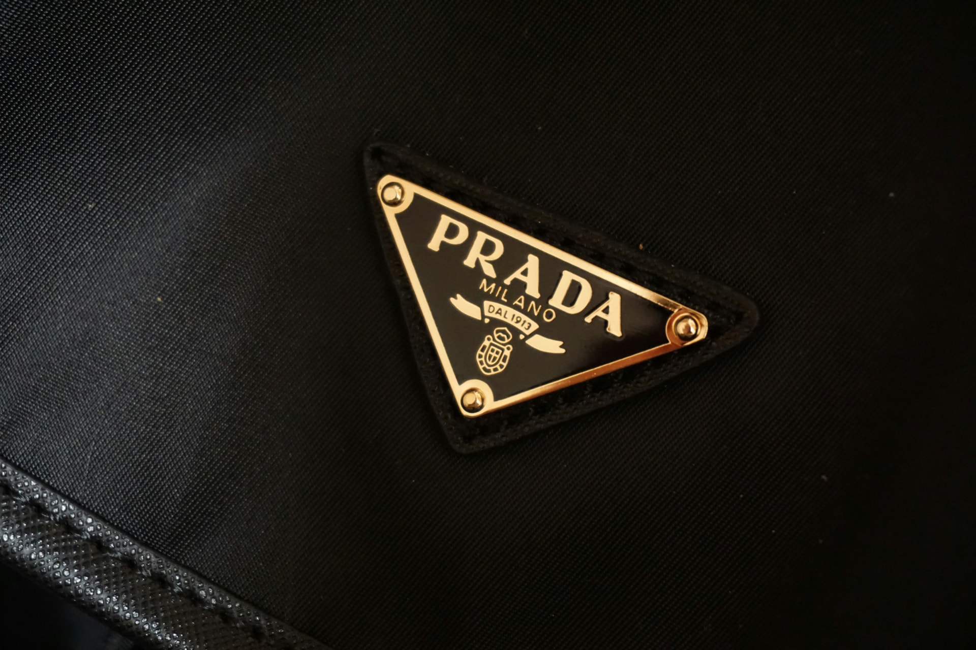 Gold Prada triangle badge on black nylon